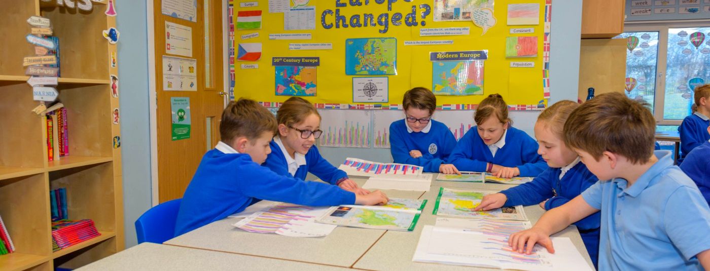 Children sat around a table in a classroom