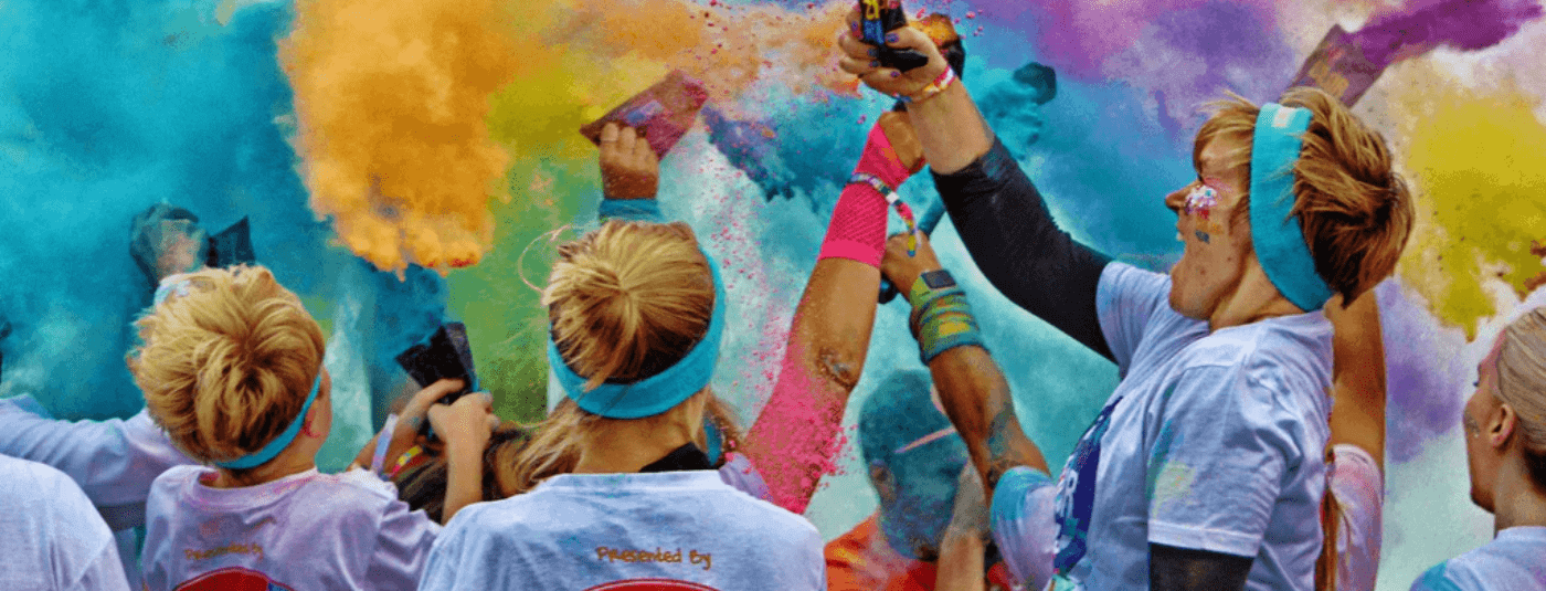 crowds of people throwing colour powder at a colour fun run