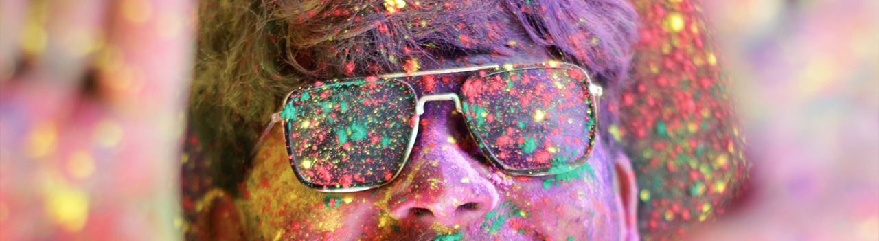 man wearing glasses covered in colour powder