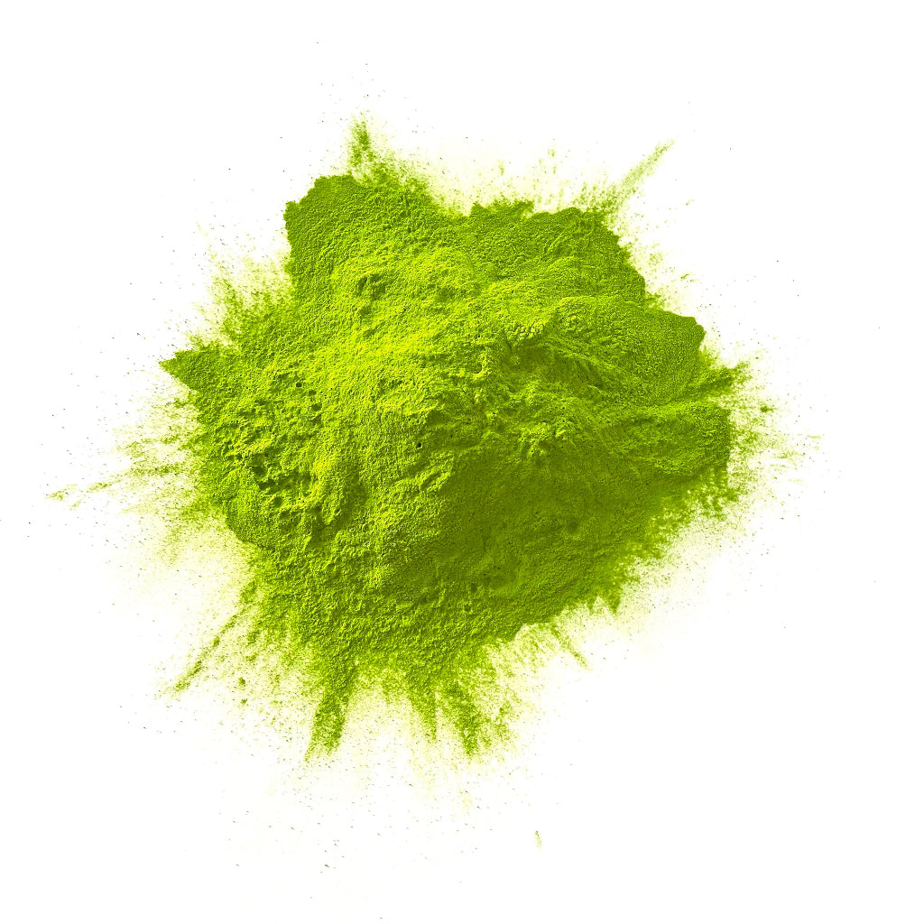 Green colour powder in a heap on a white background.