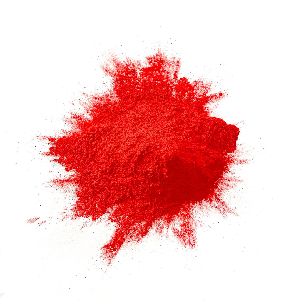 Red colour powder in a heap on a white background.