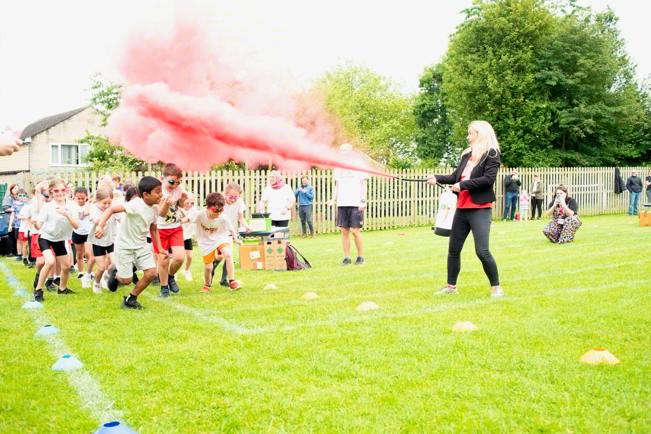 Kids at School getting blasted with a colour powder fountain on a colour run.