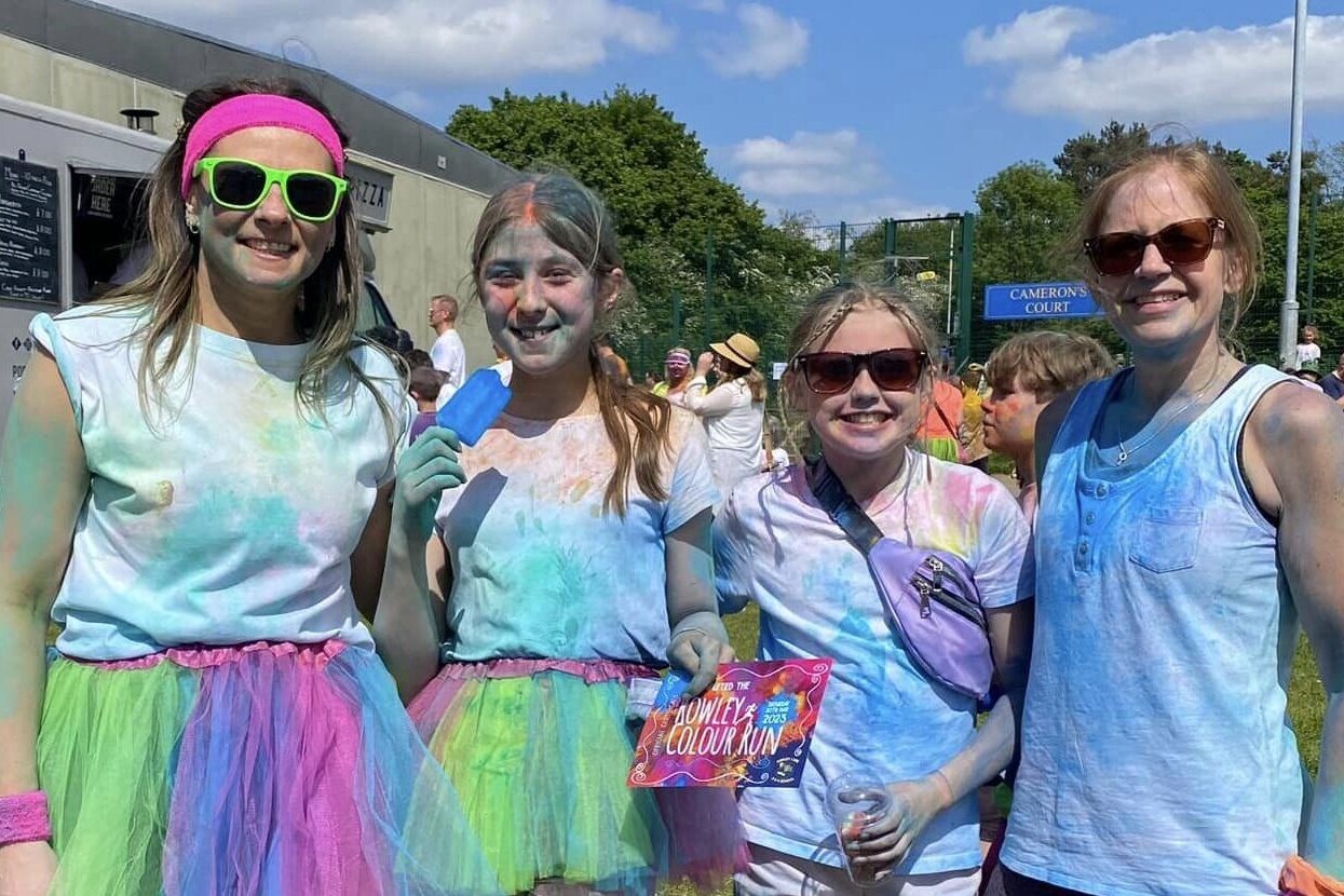 Four women standing together after taking part in a school colour run