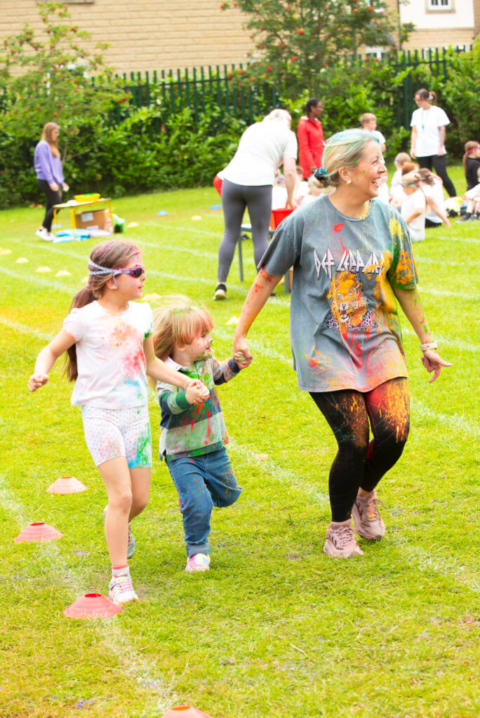 Children and an adult taking part in a school colour run fundraiser