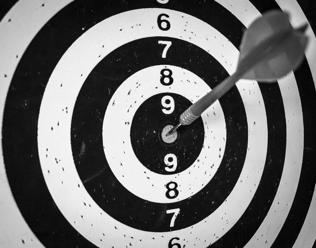 Dart hitting the centre of a target to represent school fundraising goals